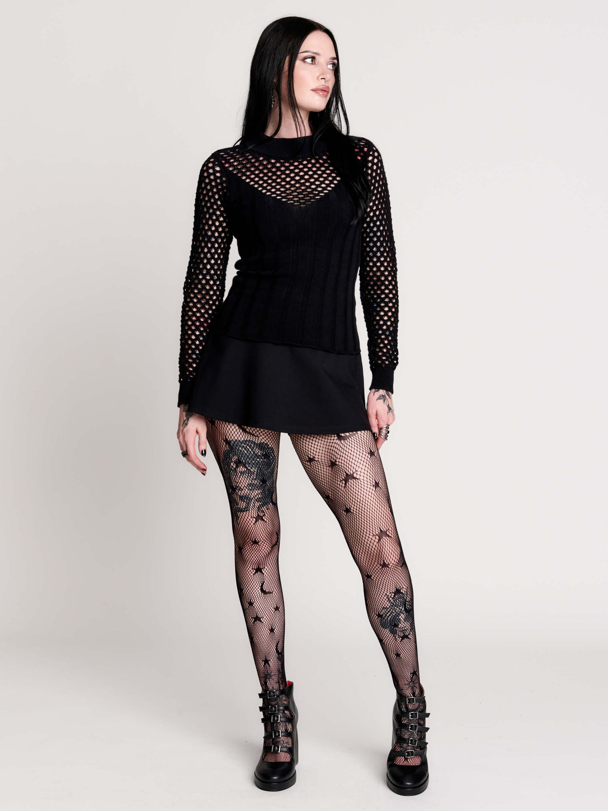 Fishnet Sweetheart Rib Sweater, a black long-sleeve top with a fitted rib-knit body and fishnet across the upper chest, shoulders, upper back and sleeves, giving a “sweetheart” illusion while keeping the sleek silhouette sleek.
