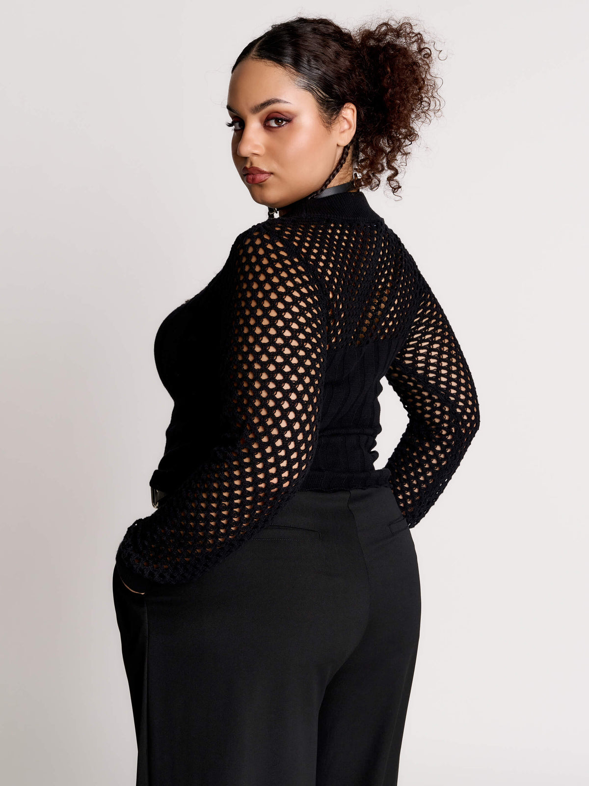 Fishnet Sweetheart Rib Sweater, a black long-sleeve top with a fitted rib-knit body and fishnet across the upper chest, shoulders, upper back and sleeves, giving a “sweetheart” illusion while keeping the sleek silhouette sleek.