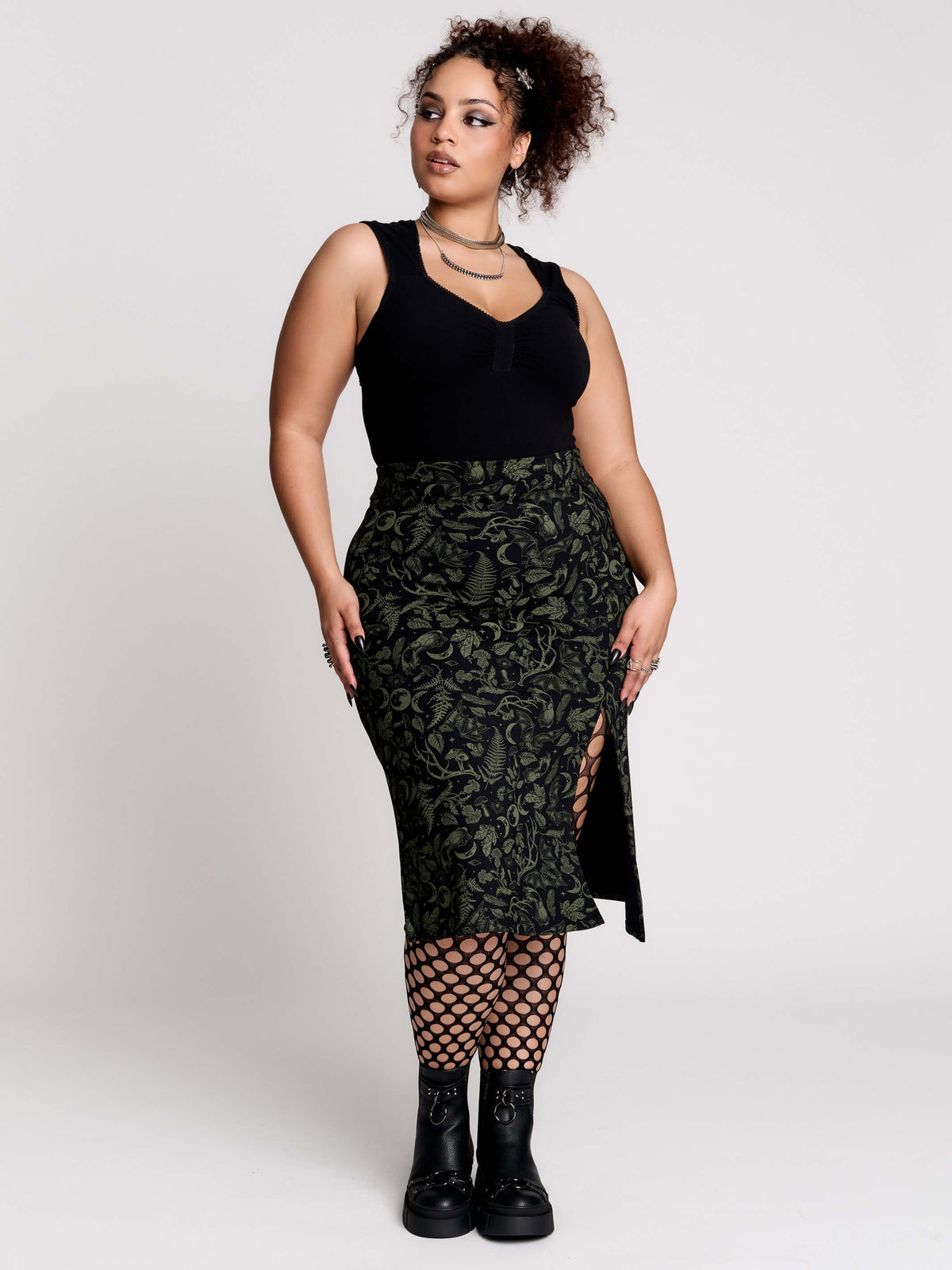 a black midi skirt with a green forest findings print.