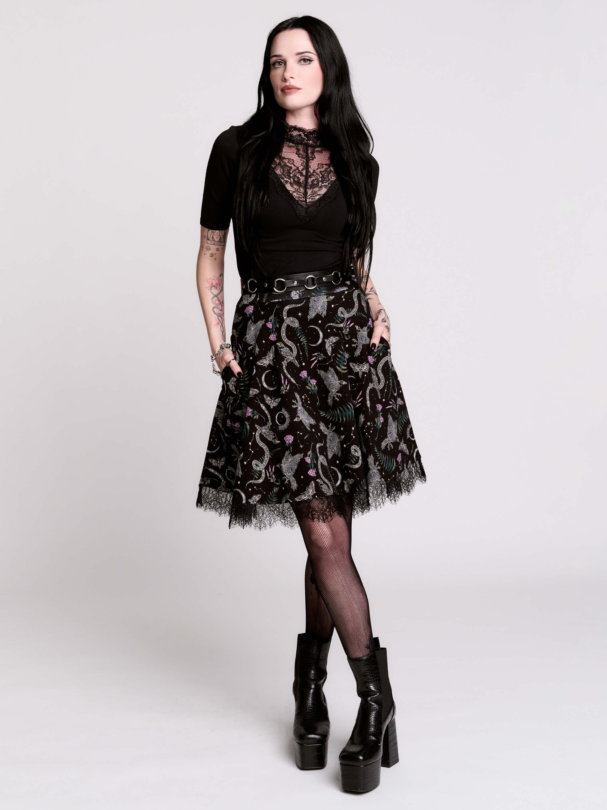 A black flared skirt featuring a gray and purple gothic print with lace hem.