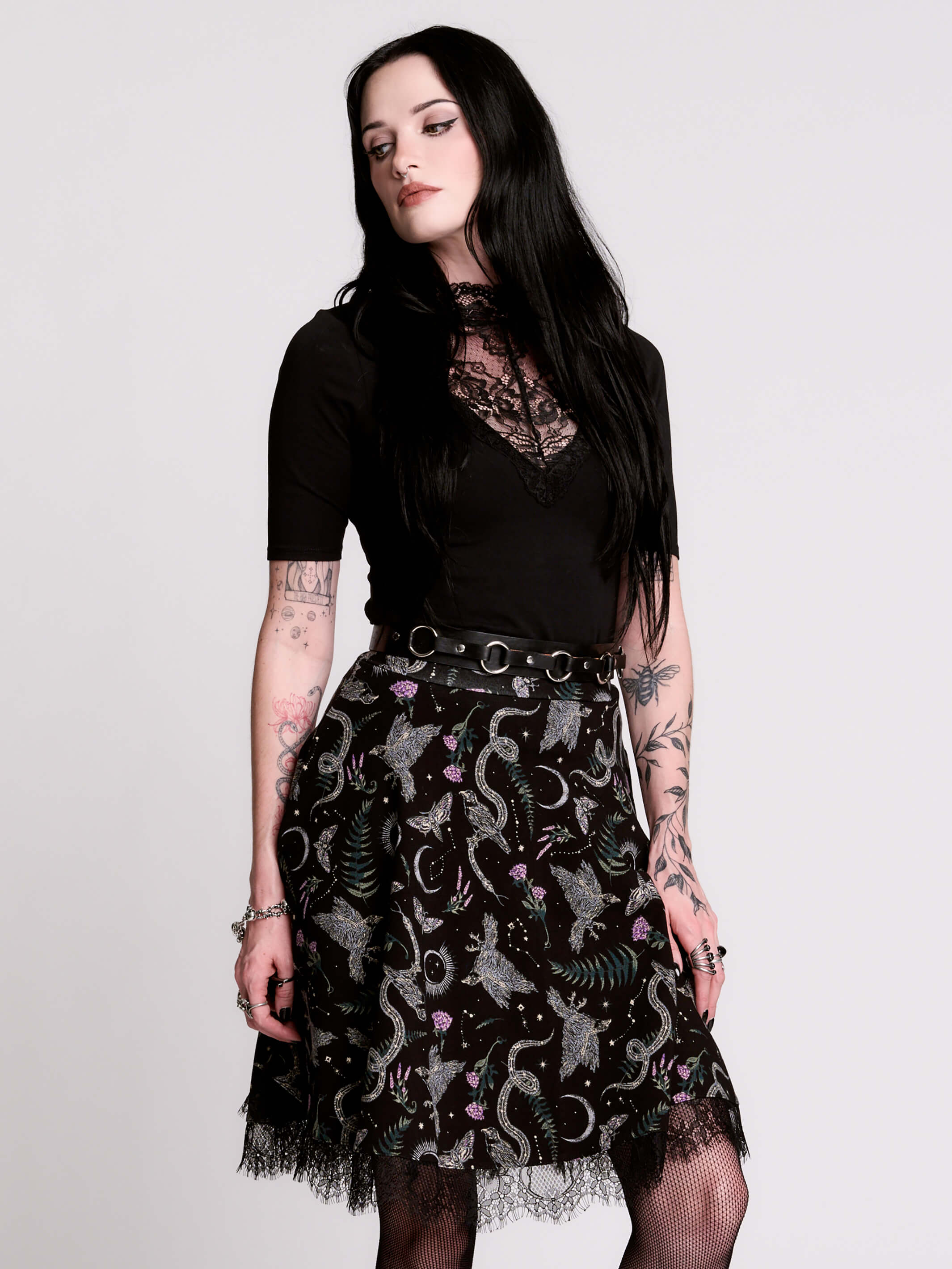 A black flared skirt featuring a gray and purple gothic print with lace hem.