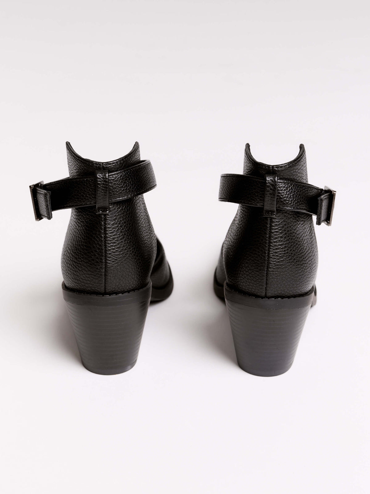 A pair of black leather ankle-strap block-heel shoes with pointed toes and silver pyramid stud embellishments.