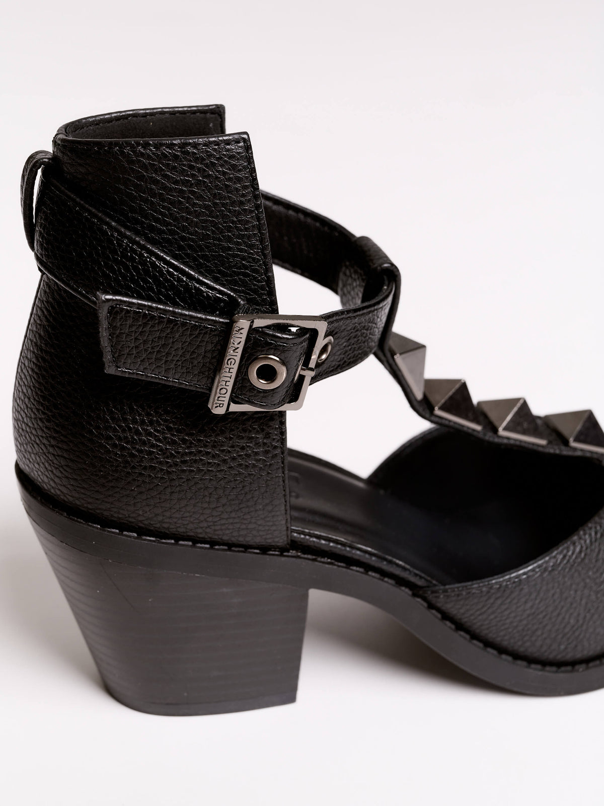 A pair of black leather ankle-strap block-heel shoes with pointed toes and silver pyramid stud embellishments.