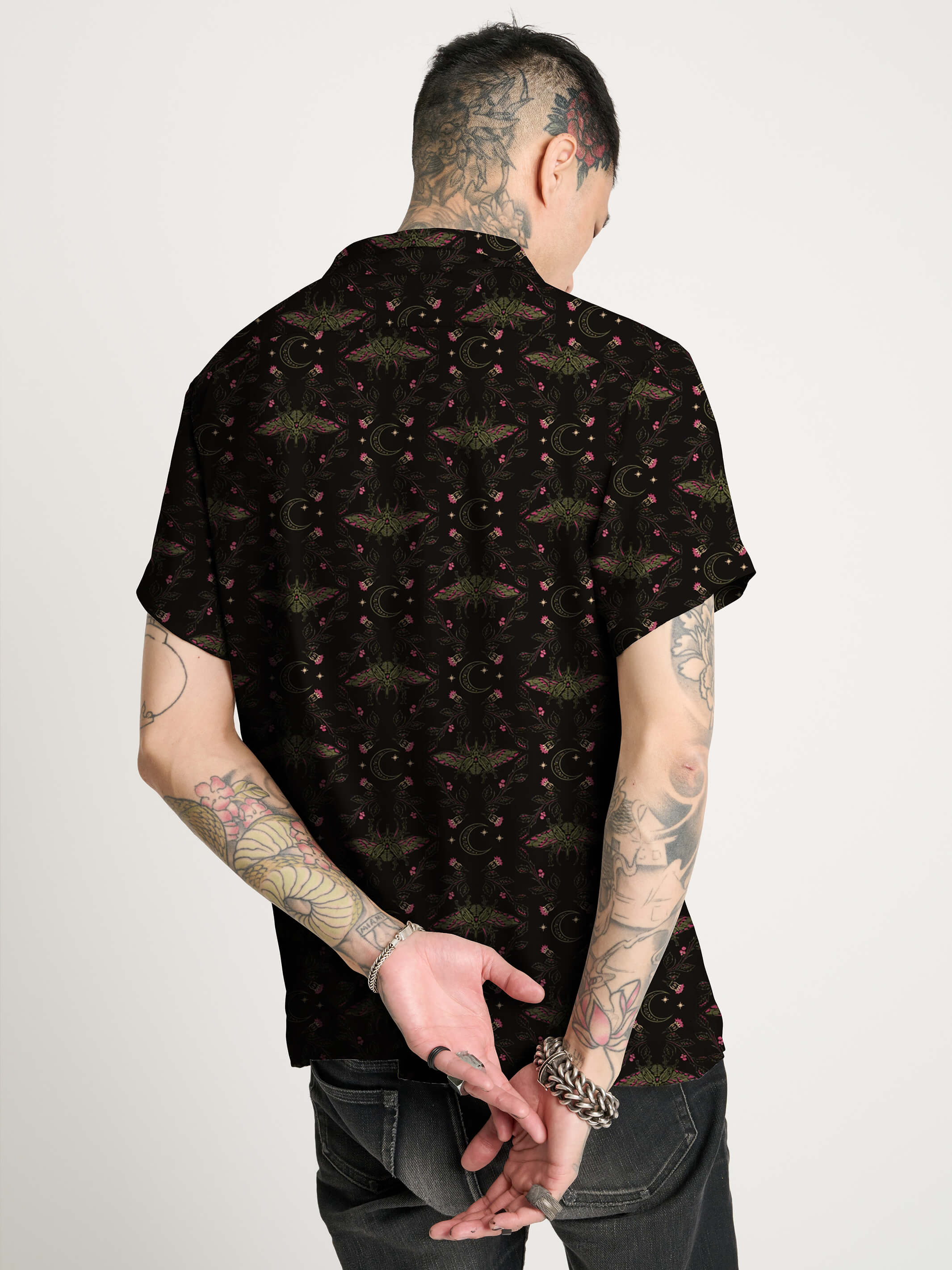 A black short-sleeve button-up shirt with repeating red and green scarab beetle pattern.