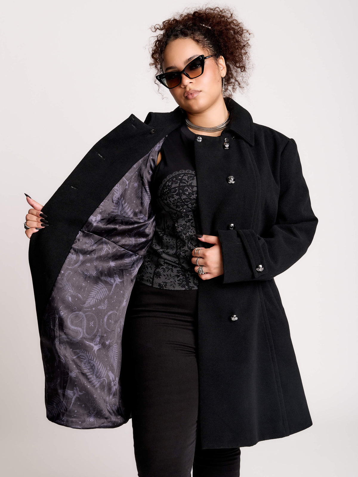 a black double-breasted coat with silver buttons and gothic dragon embroidery on the shoulder cape