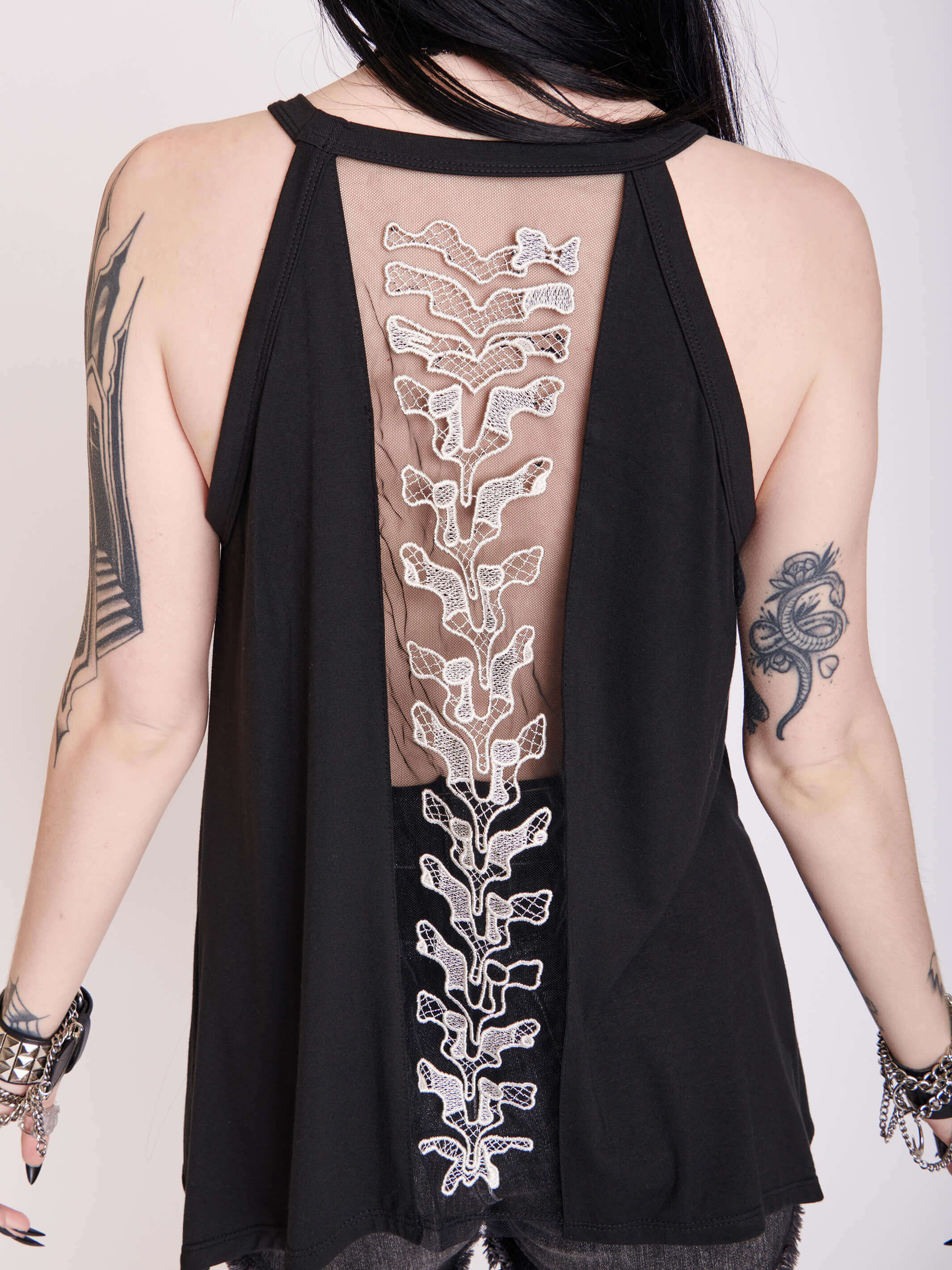 black tank with sheer back panel embroidered with spine motif