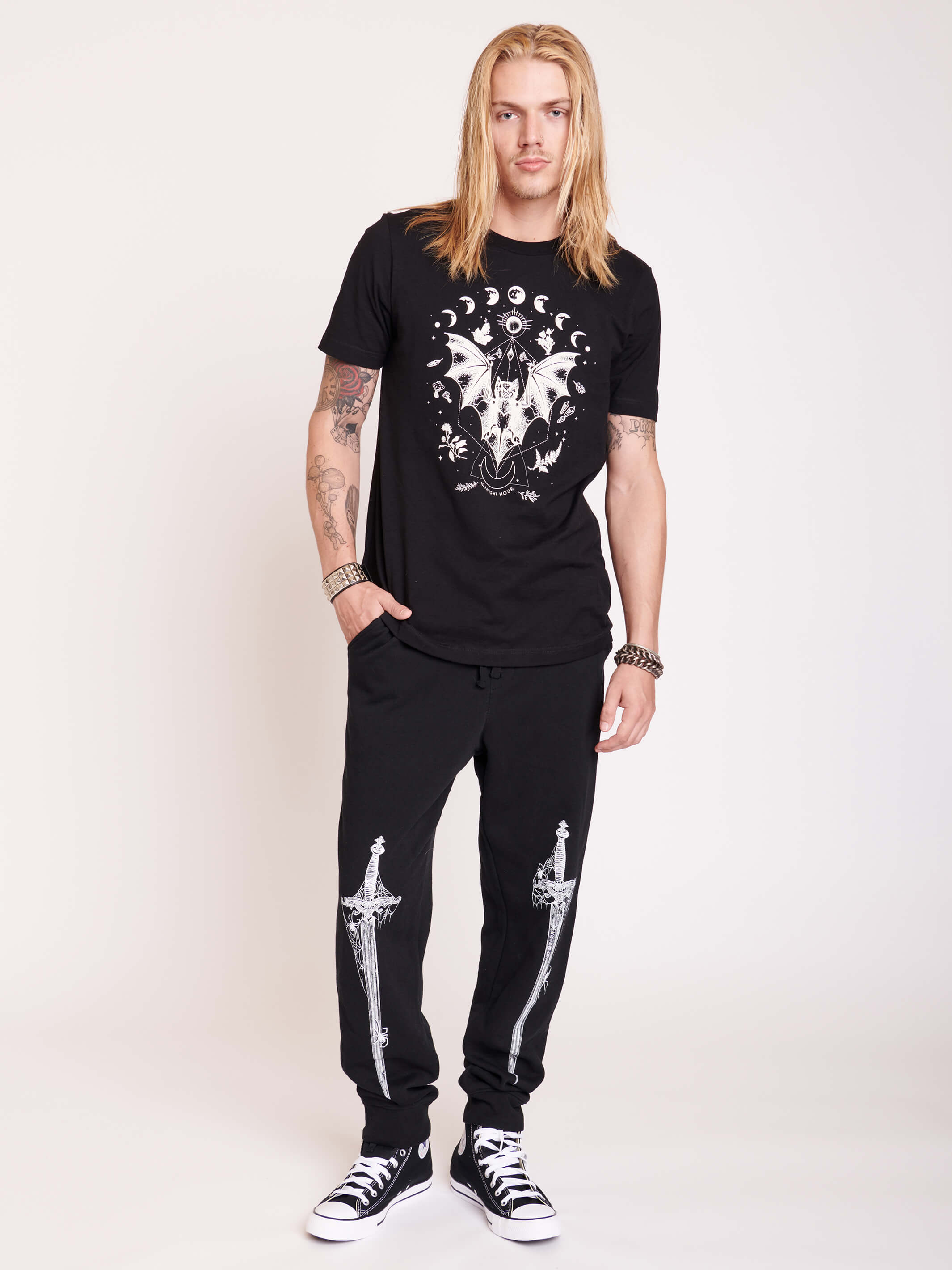 Black joggers with white dagger graphic from thighs to shins