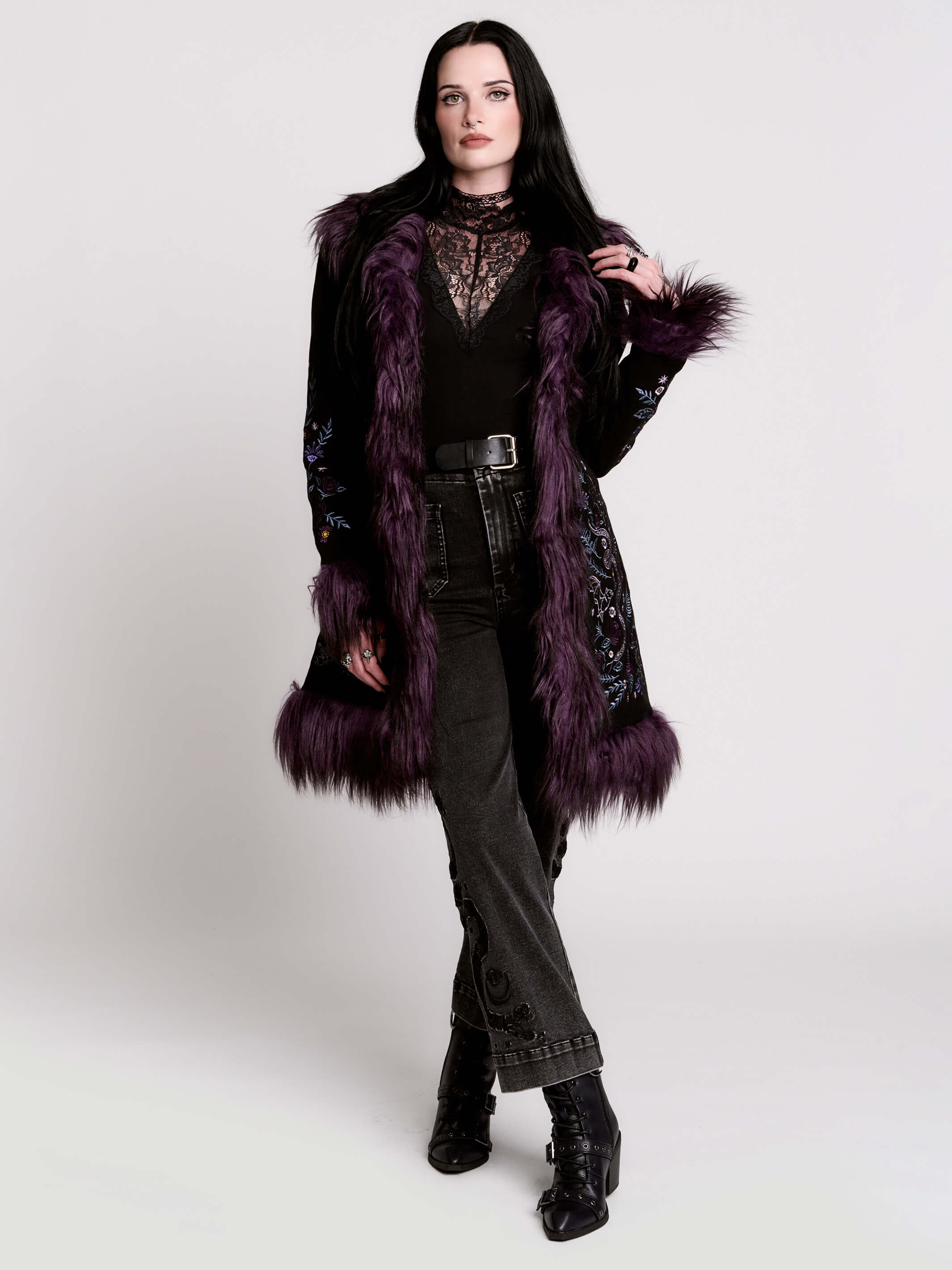 This mid-length black coat pairs a soft, suede-like finish with plush amethyst-purple faux fur trim