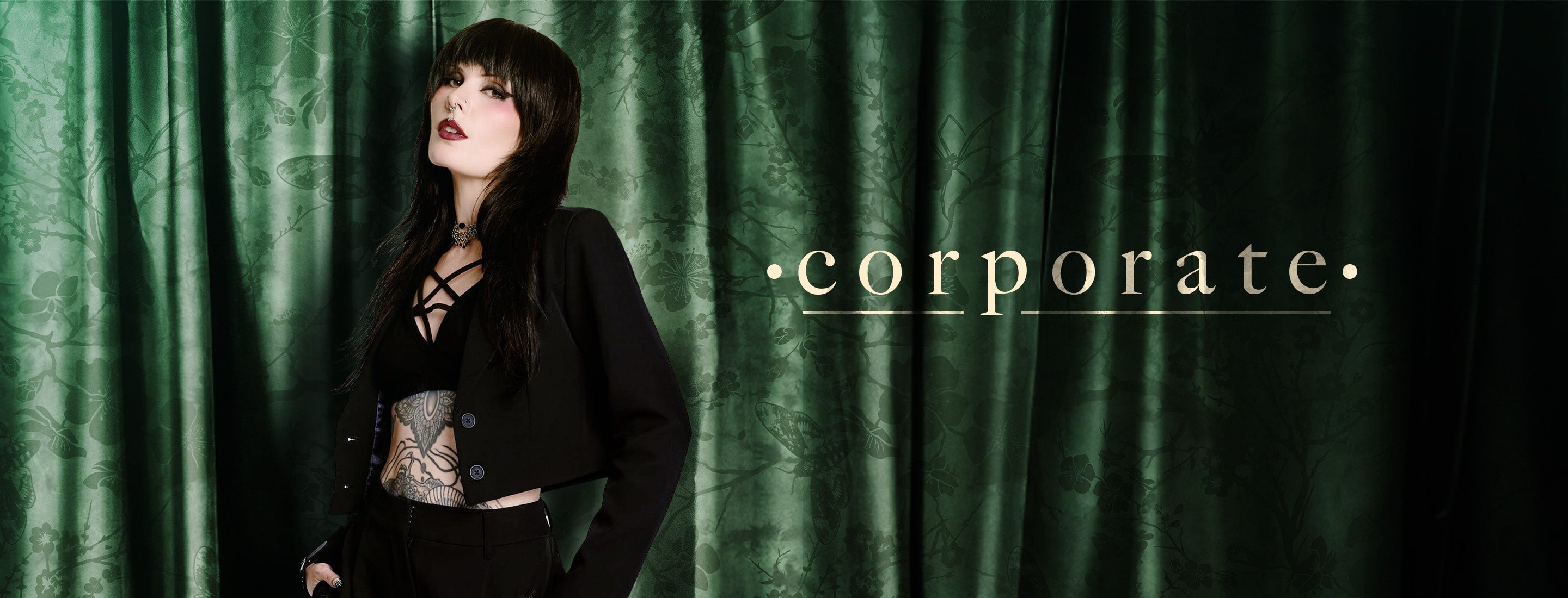 Person wearing a black outfit with tattoos against a green curtain backdrop, with 'corporate' text at the bottom.
