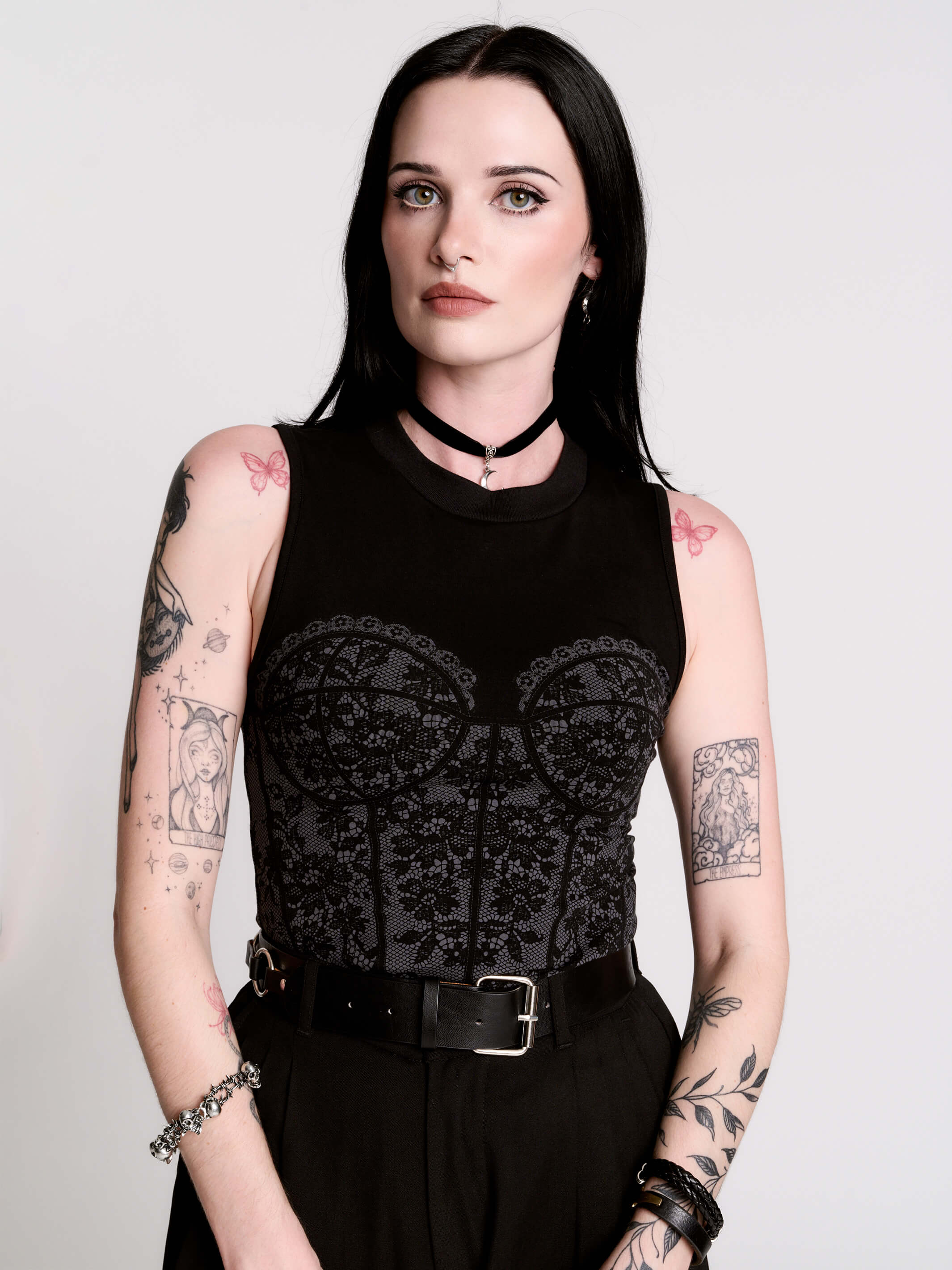 A black sleeveless top with a printed floral lace corset in light grey.