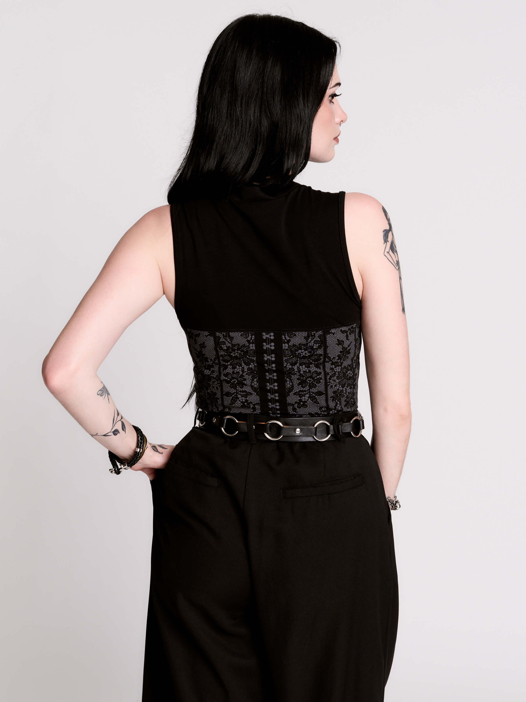 A black sleeveless top with a printed floral lace corset in light grey.