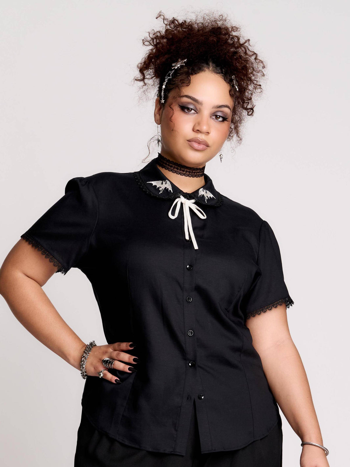 black short-sleeve blouse with white embroidered bat on collar and black lace trim