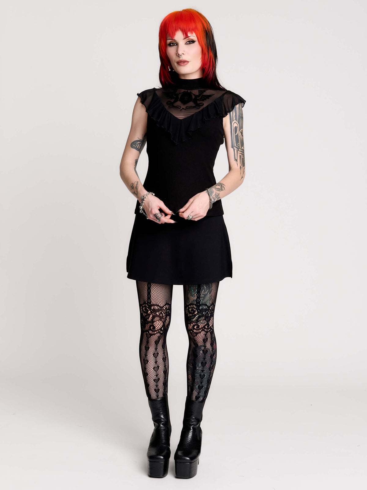 a black sheer mock-neck top with a black graphic on the chest