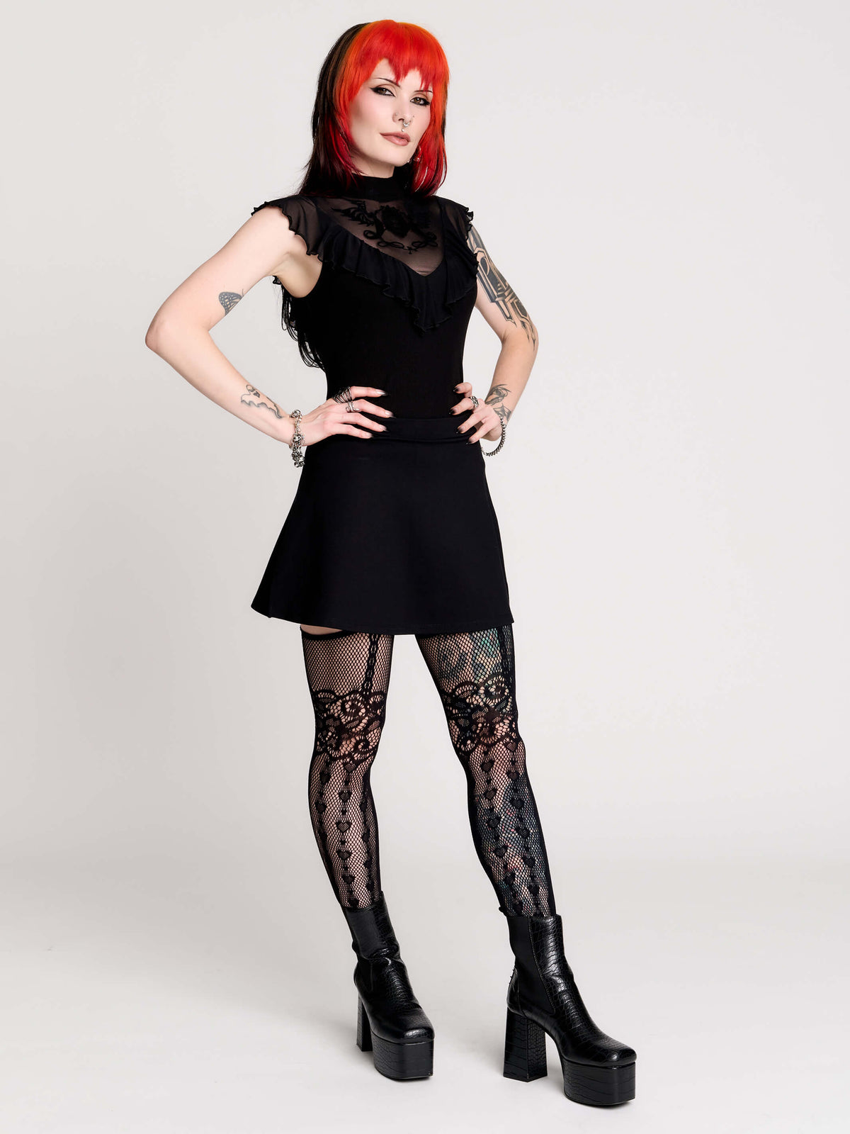 a black sheer mock-neck top with a black graphic on the chest