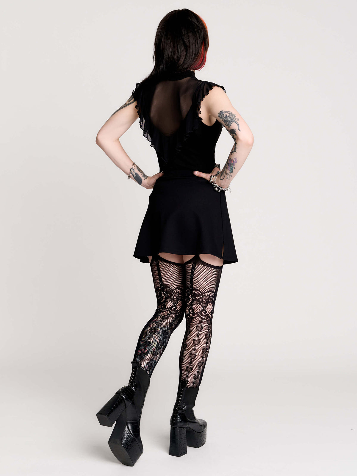 a black sheer mock-neck top with a black graphic on the chest