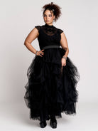 a black sheer mock-neck top with a black graphic on the chest