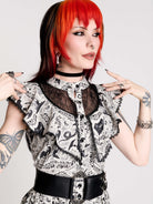 black and white gothic-style dress with a bird pattern, lace trim, and a high ruffled collar