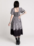 short-sleeved gray and black gothic-style midi dress with a printed illustration of a woman and winged figure at the hem