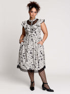 black and white gothic-style dress with a bird pattern, lace trim, and a high ruffled collar