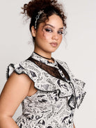black and white gothic-style dress with a bird pattern, lace trim, and a high ruffled collar