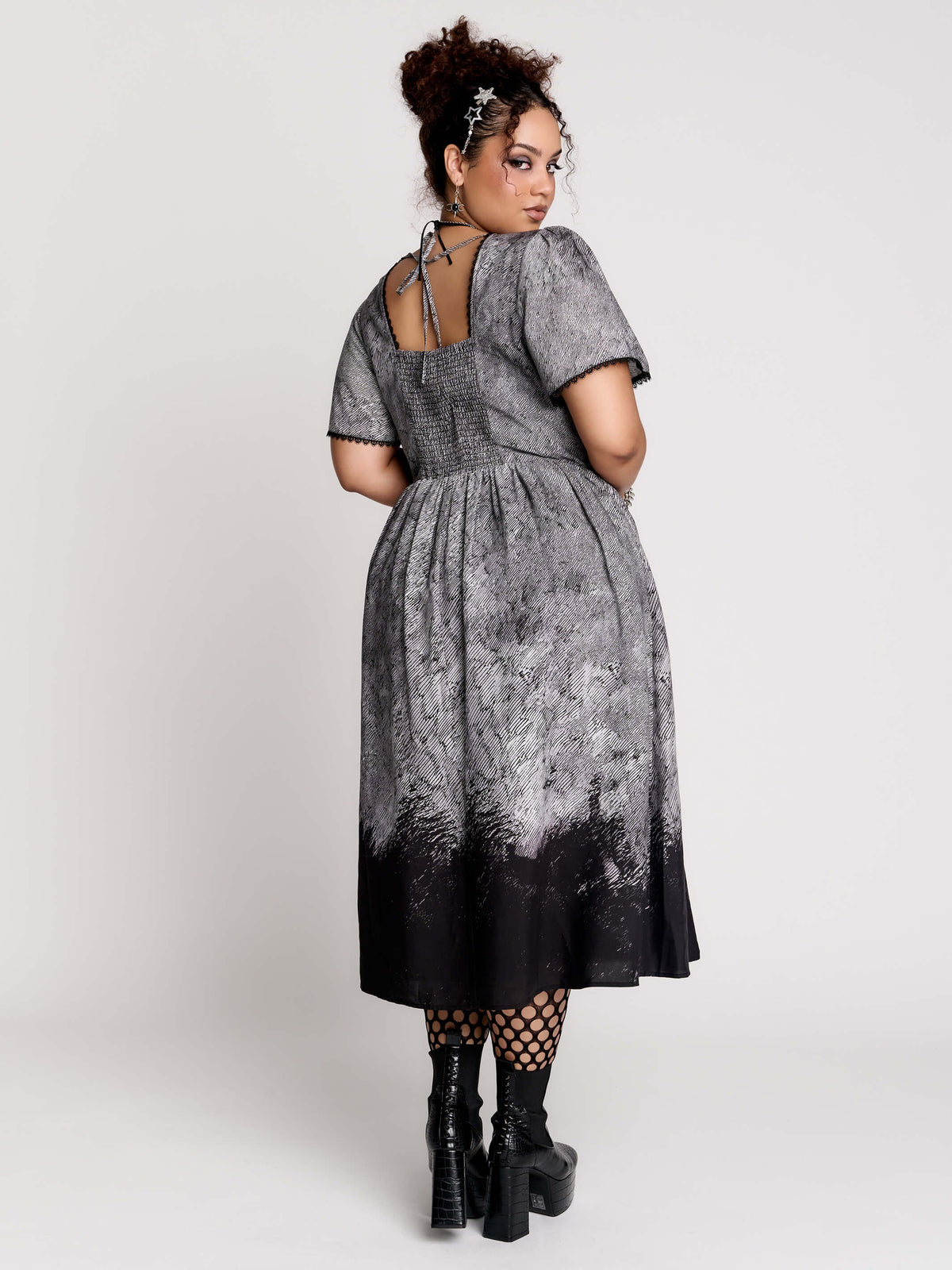 short-sleeved gray and black gothic-style midi dress with a printed illustration of a woman and winged figure at the hem