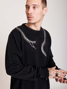 sweater with skeleton snake detail around neck.