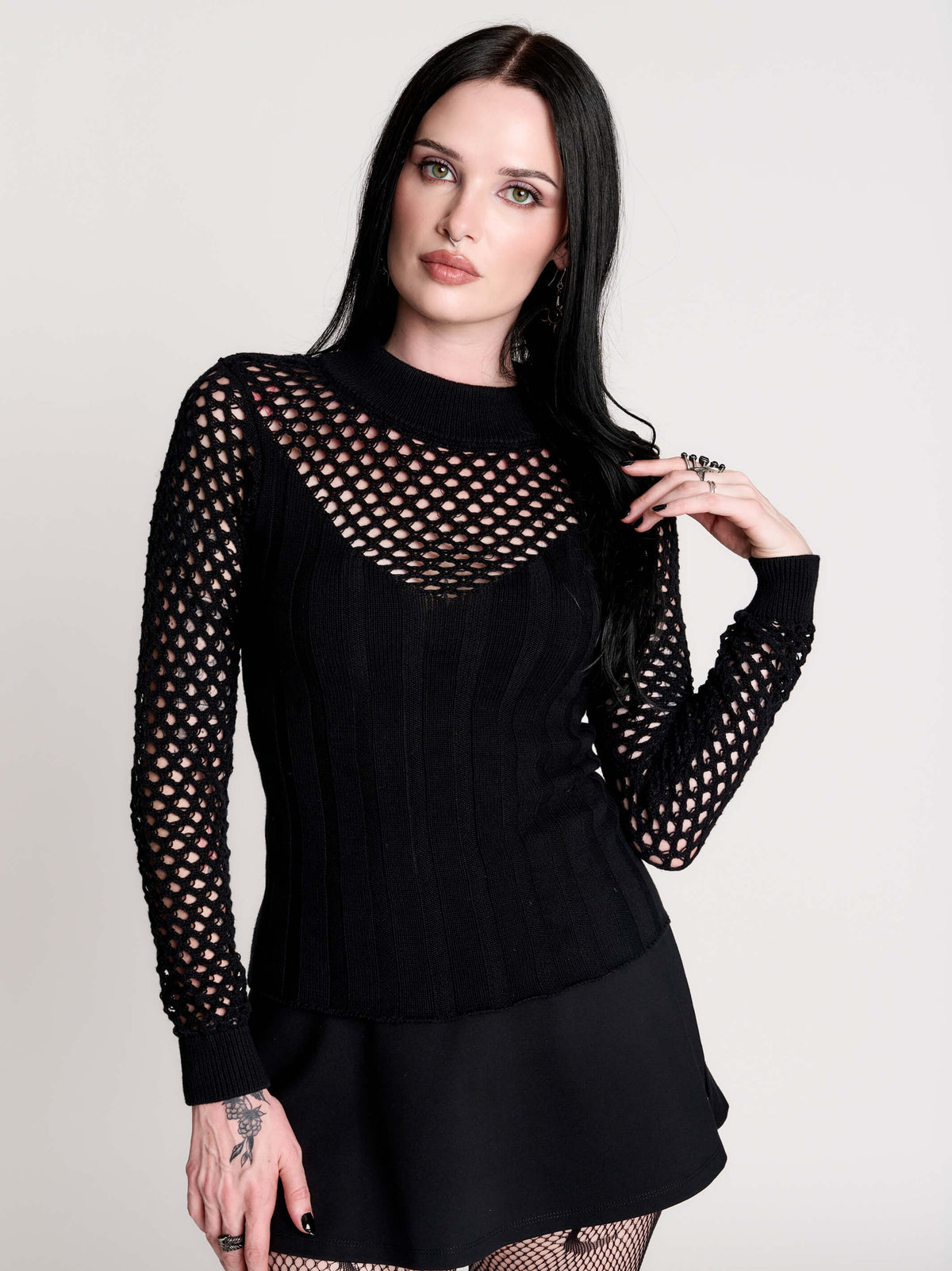 Fishnet Sweetheart Rib Sweater, a black long-sleeve top with a fitted rib-knit body and fishnet across the upper chest, shoulders, upper back and sleeves, giving a  “sweetheart” illusion while keeping the sleek silhouette sleek.