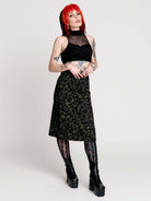 a black midi skirt with a green forest findings print. 