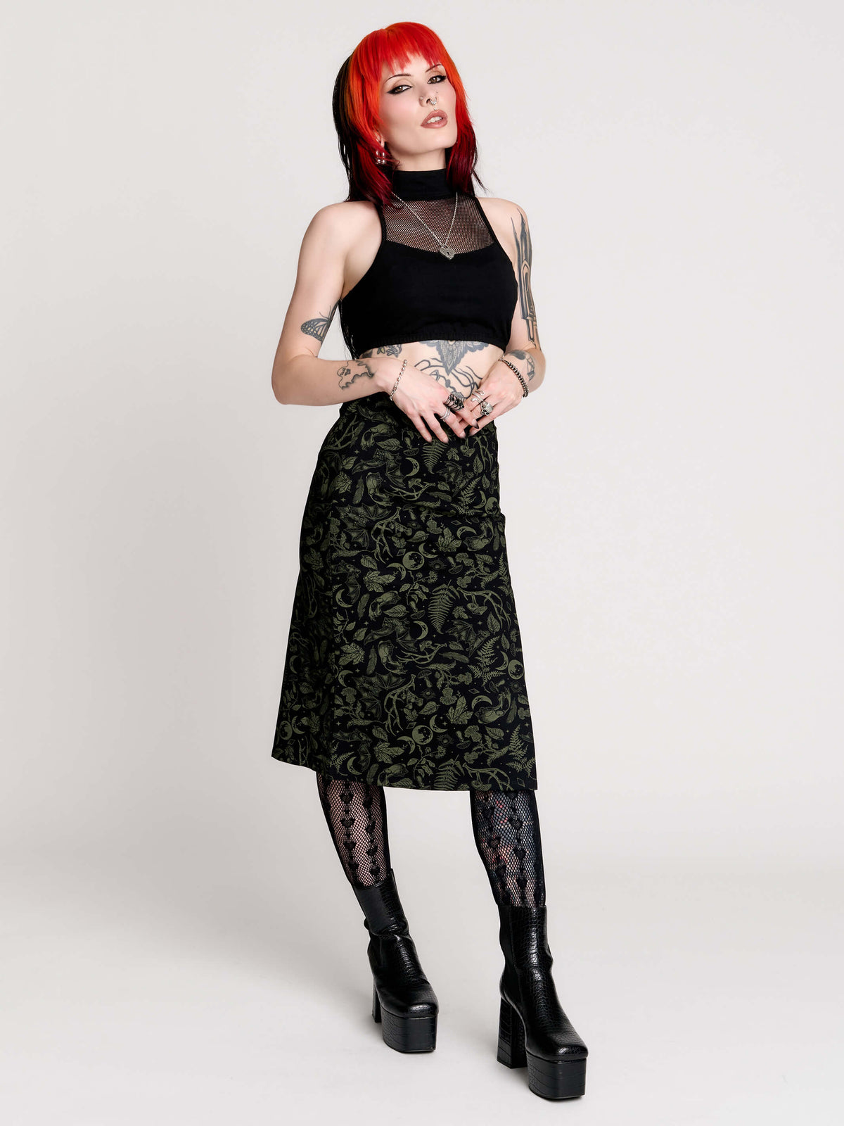 a black midi skirt with a green forest findings print. 
