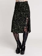 a black midi skirt with a green forest findings print. 