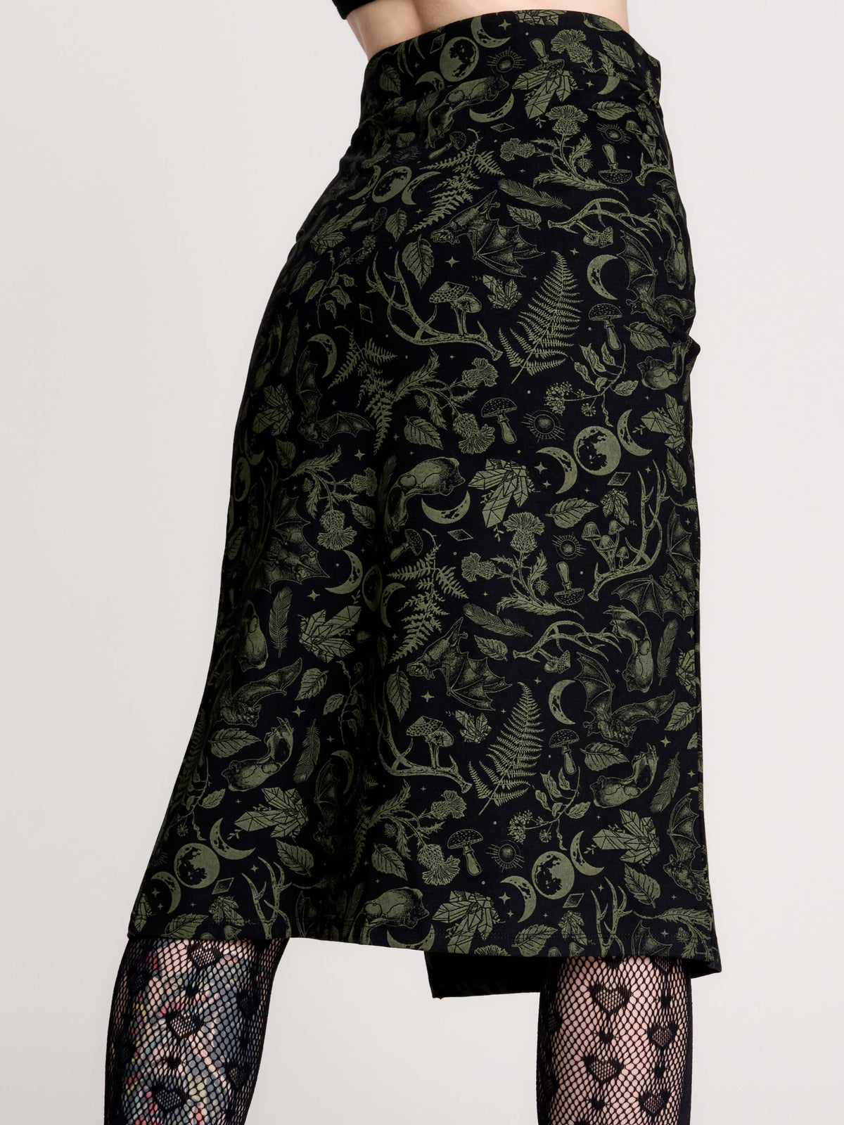 a black midi skirt with a green forest findings print. 