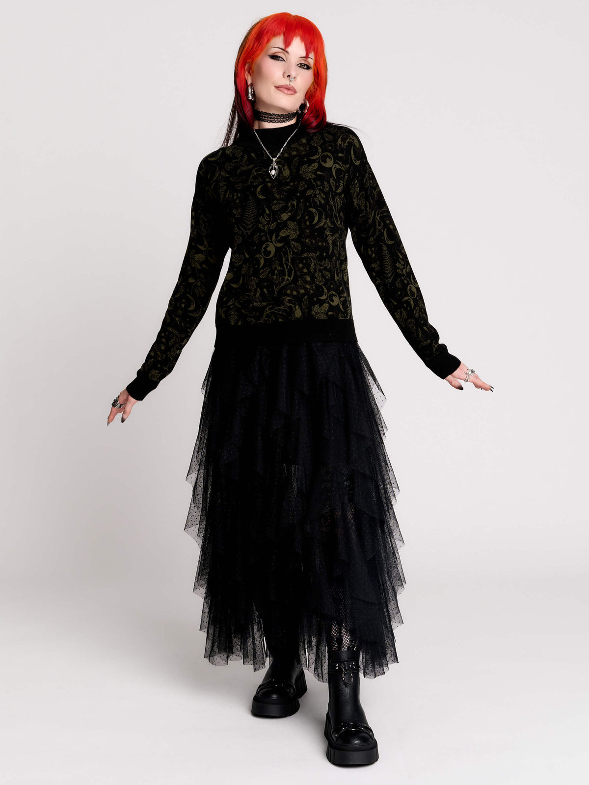 a black long-sleeve top with an intricate olive green forest findings pattern