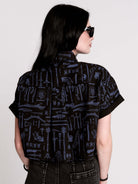 Armory Cropped Shirt is a boxy, cropped, short-sleeve button-down that mixes crisp classic shirting with dark, gothic illustration. 