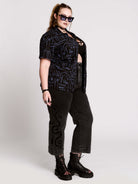short-sleeve button-down that mixes crisp classic shirting with dark, gothic illustration. 