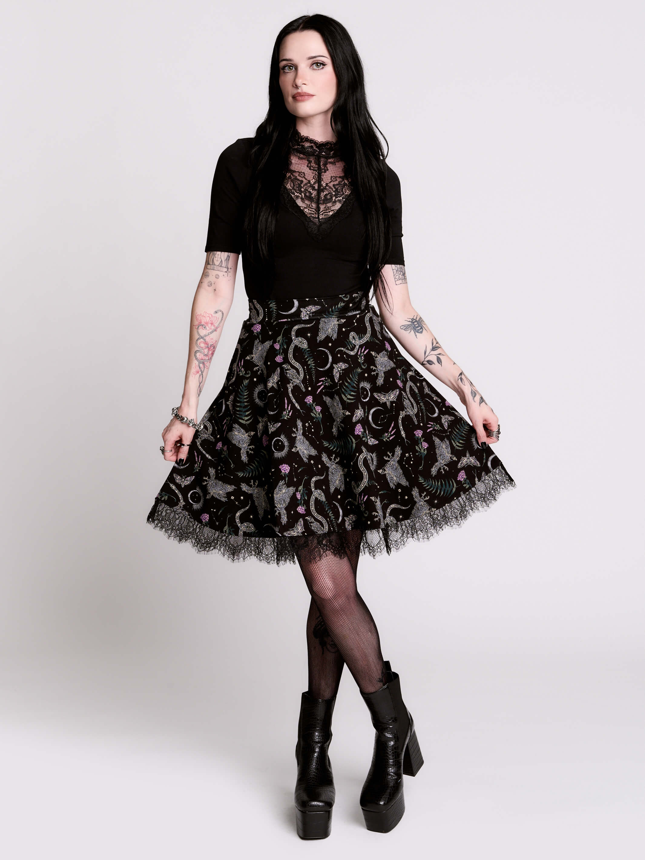 A  black flared skirt featuring a gray and purple gothic print with lace hem.