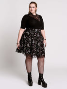A  black flared skirt featuring a gray and purple gothic print with lace hem.