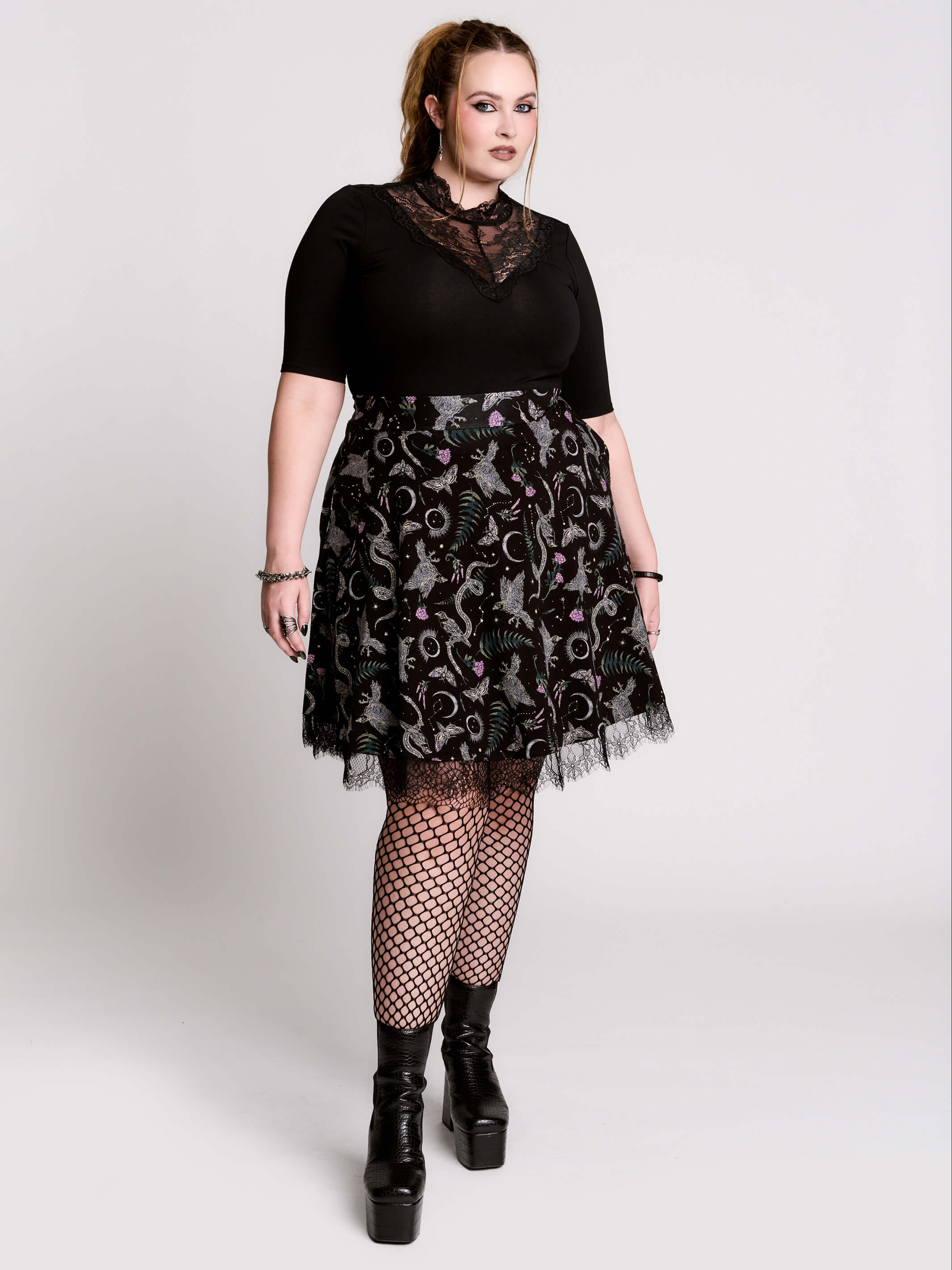 A  black flared skirt featuring a gray and purple gothic print with lace hem.