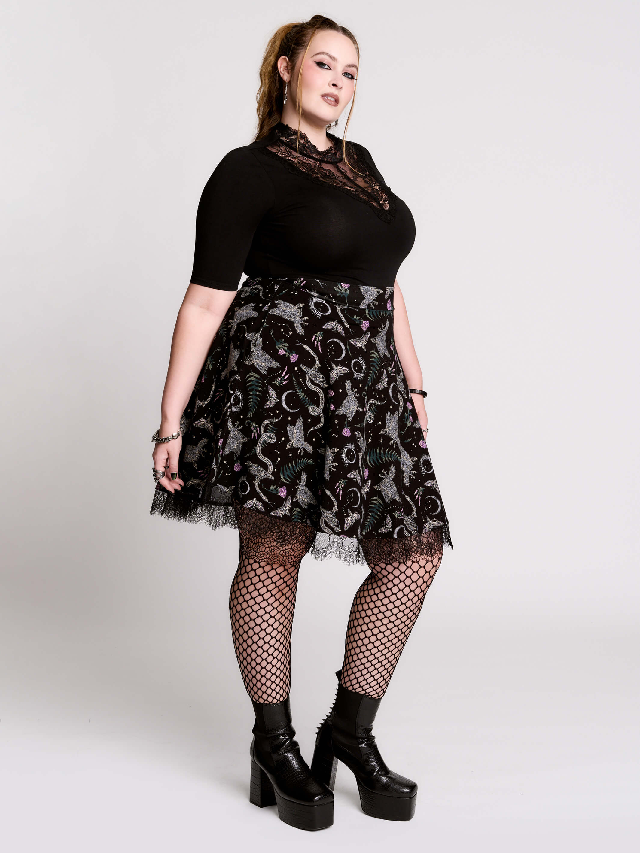 A  black flared skirt featuring a gray and purple gothic print with lace hem.