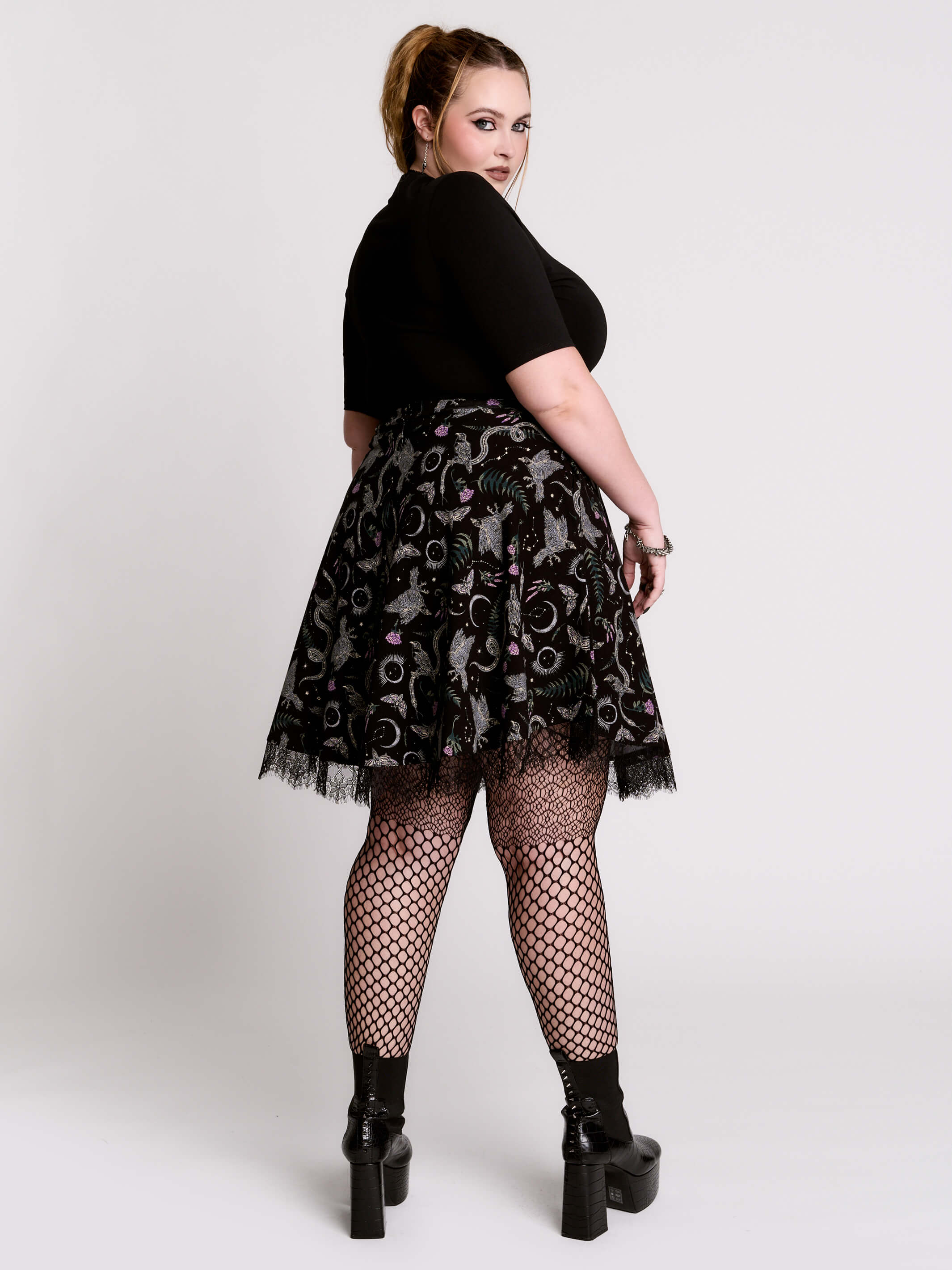 A  black flared skirt featuring a gray and purple gothic print with lace hem.