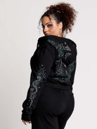 black hoodie with intricate green, pink, and white print on the back, hood and sleeves