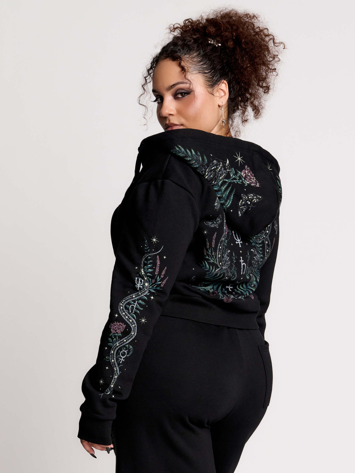 black hoodie with intricate green, pink, and white print on the back, hood and sleeves