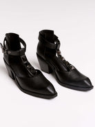 A pair of black leather ankle-strap block-heel shoes with pointed toes and silver pyramid stud embellishments.