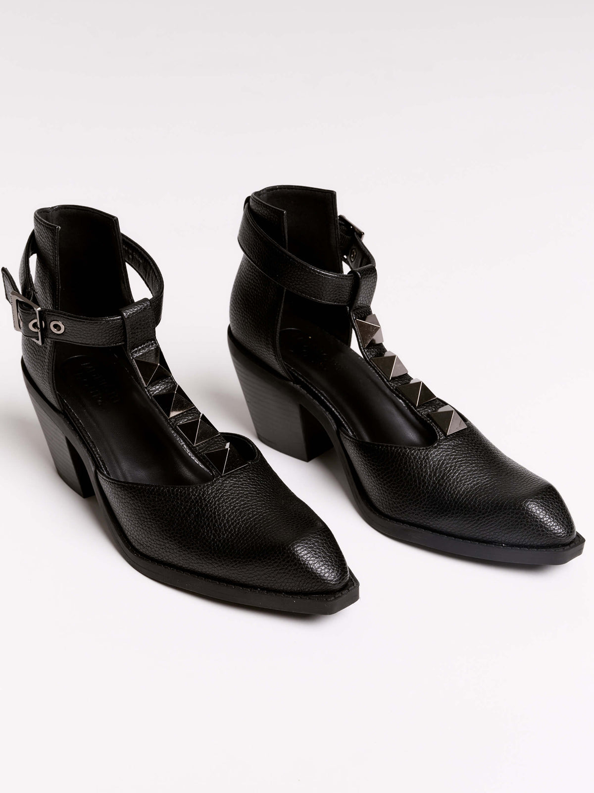 A pair of black leather ankle-strap block-heel shoes with pointed toes and silver pyramid stud embellishments.