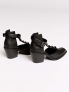A pair of black leather ankle-strap block-heel shoes with pointed toes and silver pyramid stud embellishments.
