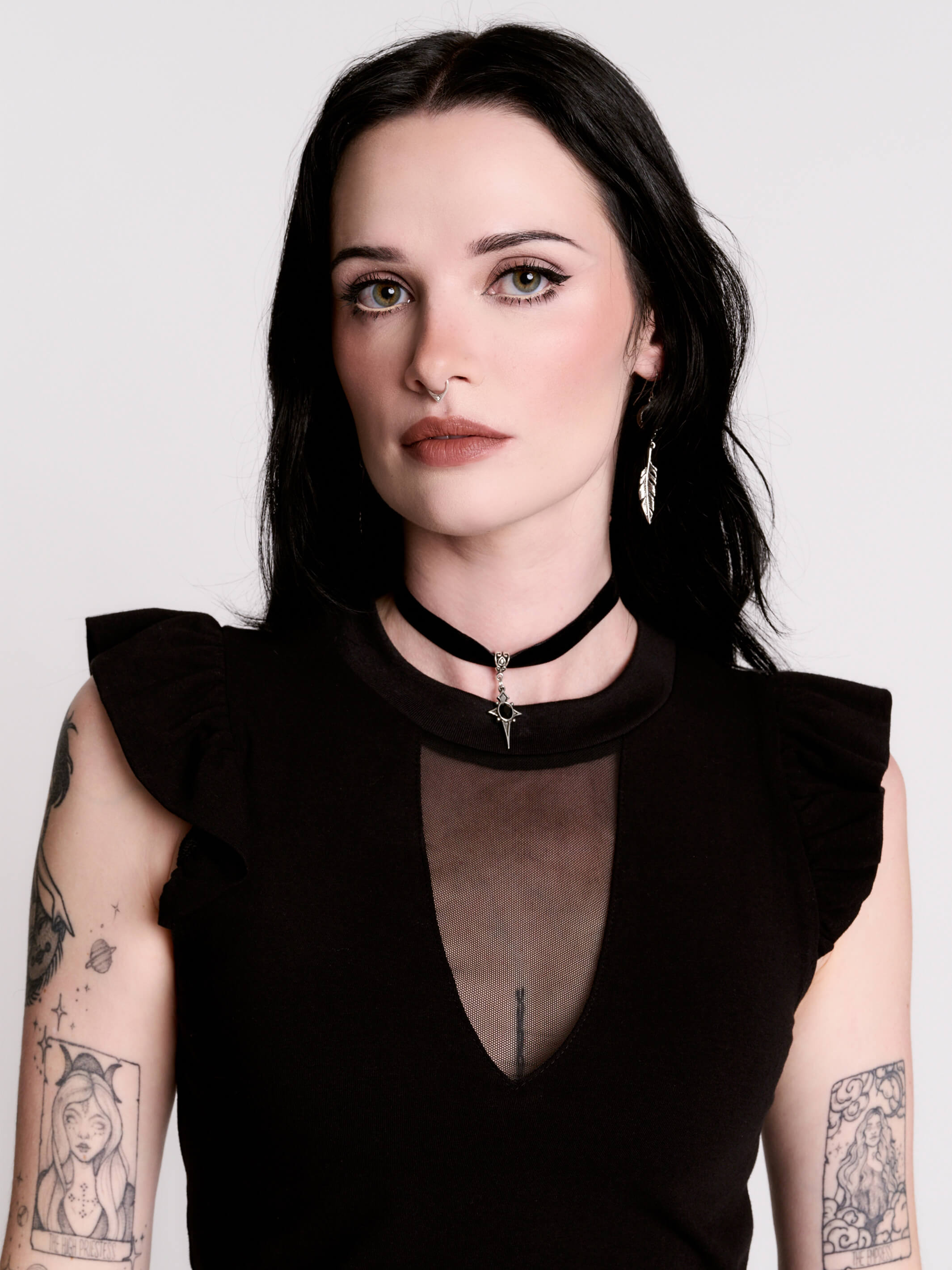 A black ruffled sleeveless top with a sheer chest cutout.