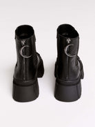 Black chunky platform ankle boots with buckle straps.