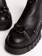 Black chunky platform ankle boots with buckle straps.