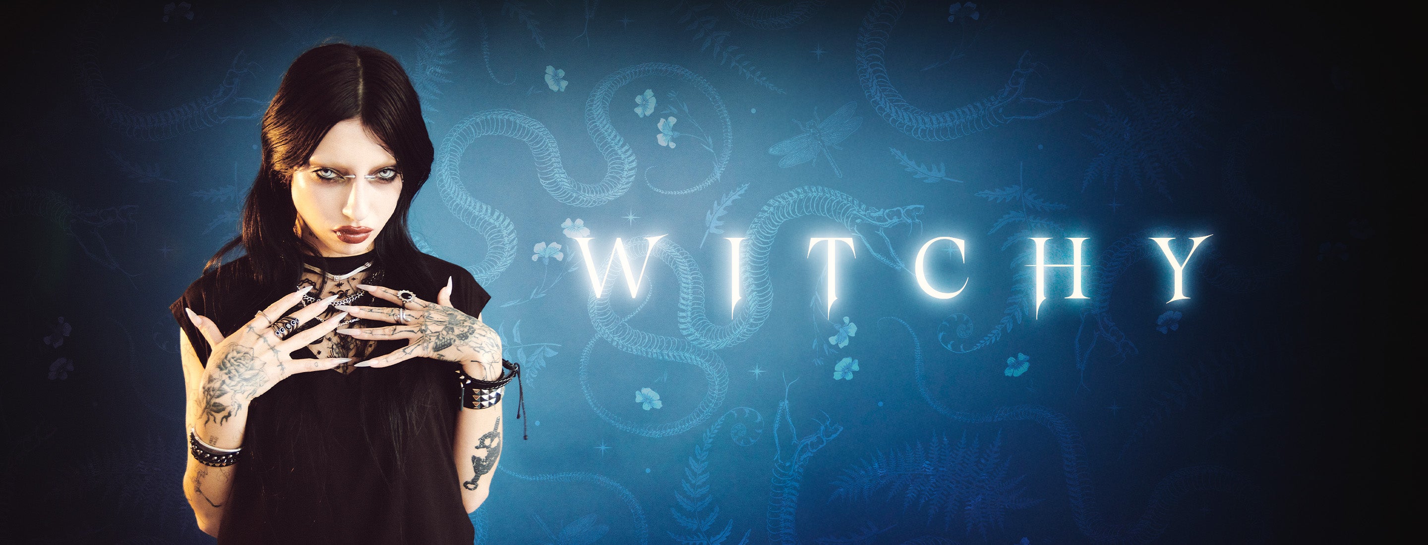 Woman with skeleton hands against a dark blue background with 'WITCHY' text