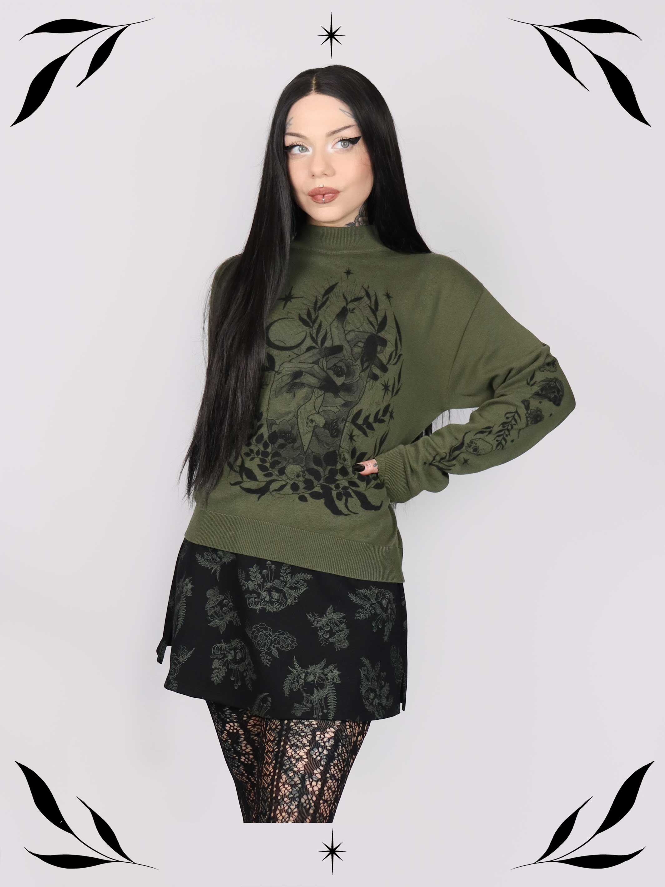 an olive green mock-neck sweater featuring a black gothic graphic