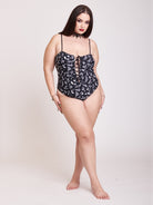 black one piece swim suit with a white all over print and lace up detail front and back middle